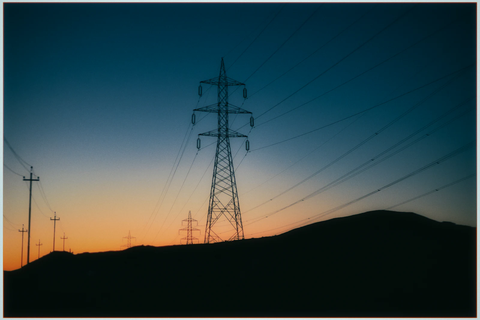 Power lines silhouetted against a twilight sky